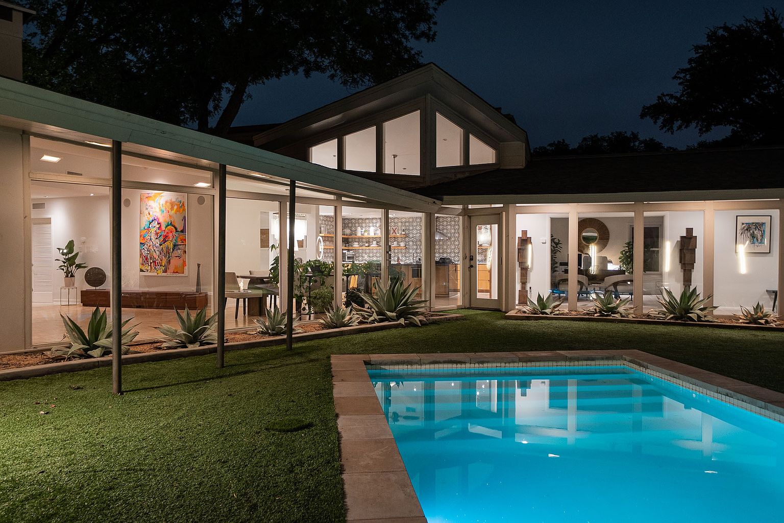 Listing photo: backyard pool and glass walls of the Abilene home